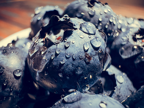 Freshly picked juicy blueberries in the bowl, macro close up. Blueberries background. Concept of healthy nutrition, organic food. Vegan and vegetarian