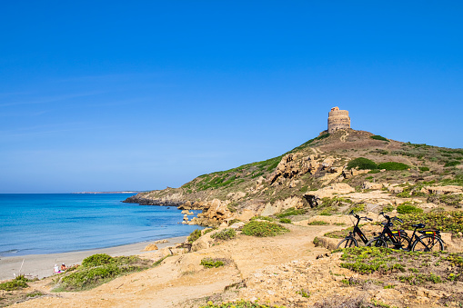 Tourists arrived by bike on the beach of the scenic Capo San Marco in the Sinis Peninsula, lapped by turquoise waters