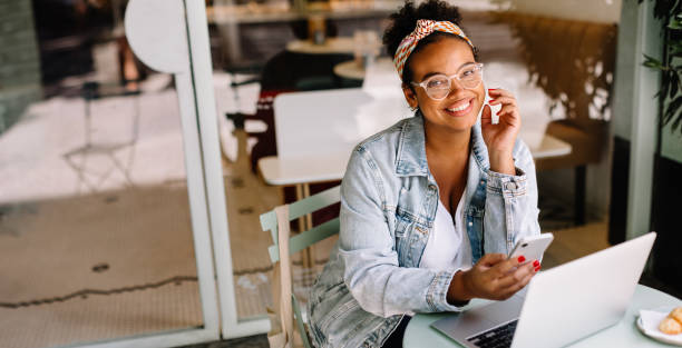 istock Business woman using laptop and smartphone in cafe 1629582766