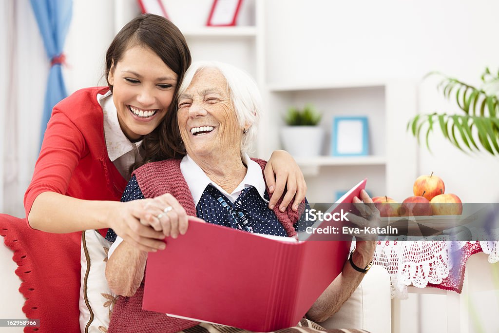 Memories Grandmother showing old photos to her granddaughter Senior Adult Stock Photo