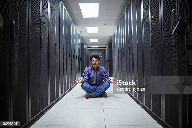 A Business Man Doing Yoga In The Network Server Room Stock Photo - Download Image Now