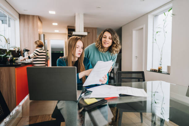 Mother helping daughter studying at home