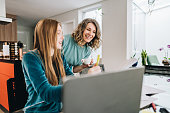 Mother helping daughter studying at home