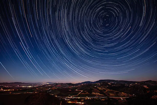 Beautiful track star image during a night in Tuscany. Trajectories of aircraft and shooting stars in the sky. Long exposure for trails of stars.