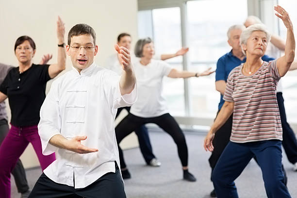 les retraités faire des exercices de tai-chi - tai chi photos et images de collection