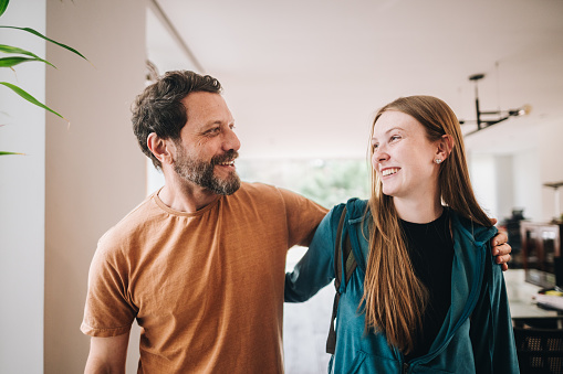 Father and daughter talking while walking at home