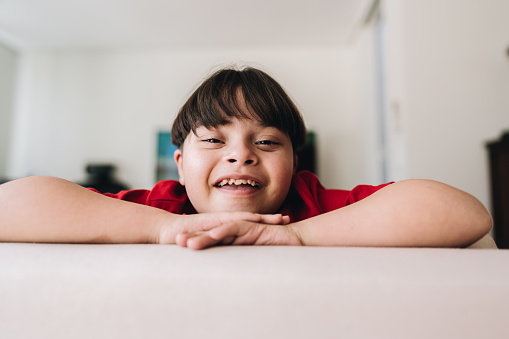 Portrait of a boy with down syndrome at home