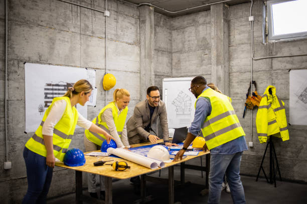istock Group of architects and construction engineers having a meeting at build site analyzing building plant and talking about project. 1629612986