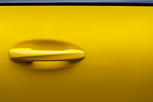 Close up of door handle of a yellow car, Germany Berlin