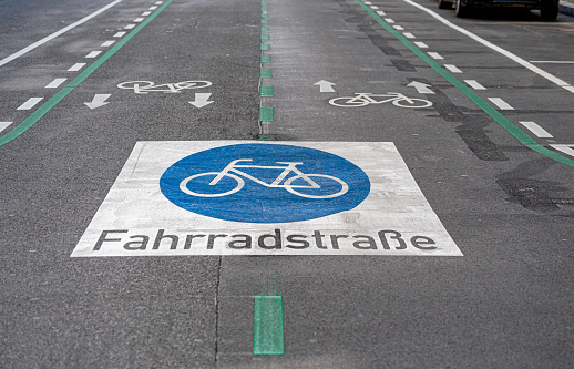 Bike lane sign on the ground, simple white bike symbol painted on the path, road, closeup detail, nobody. Cycling, biking designated areas in the city, cycle lanes infrastructure concept, no people