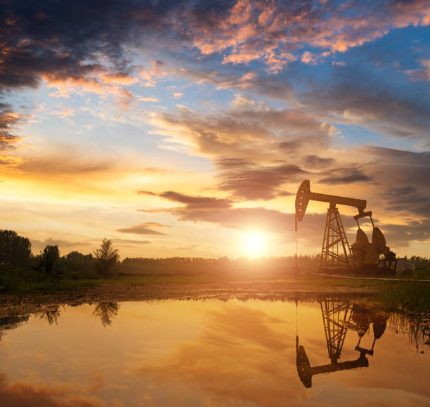 Oil pump in silhouette at sunset stock photo