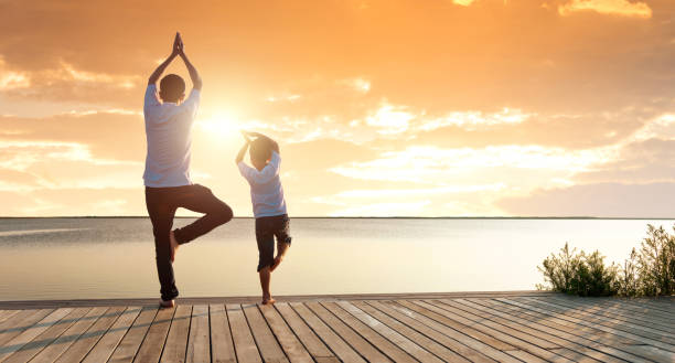istock Father and son practicing yoga at the seaside 1629631593