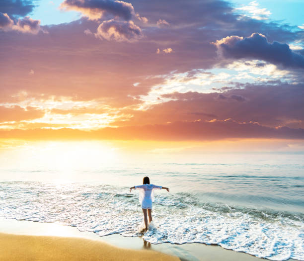 istock Happy woman standing at the beach 1629631808