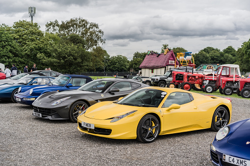 Tarporley, Cheshire, England, July 30th 2023. Yellow Ferrari 458 Spider and grey F12 Berlinetta at a supercar meet.