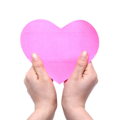 Woman's Hands Holding pink Heart isolated on white background