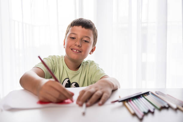 istock 9 year old boy drawing a heart shape at home 1629642703