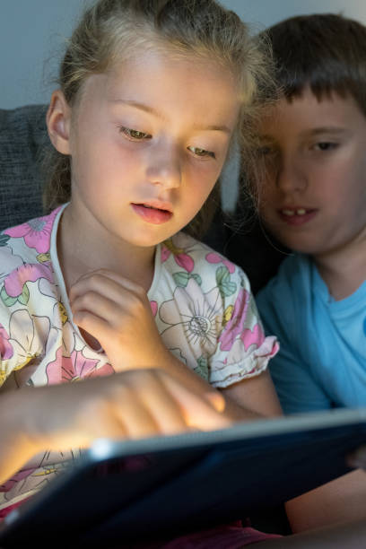istock Girl and boy using digital tablet at home 1629643253