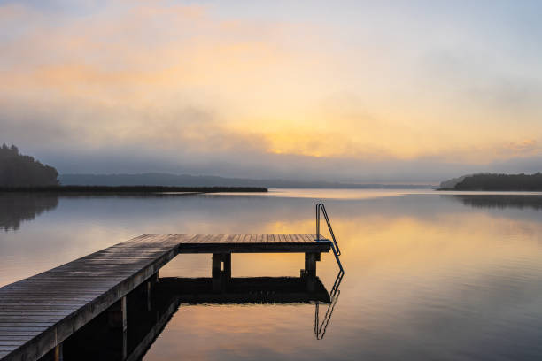 istock Bathing jetty at the lake Schaalsee during sunrise in Seedorf, Germany 1629663027