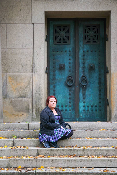 istock a woman sits on the steps in front of a gate 1629663548