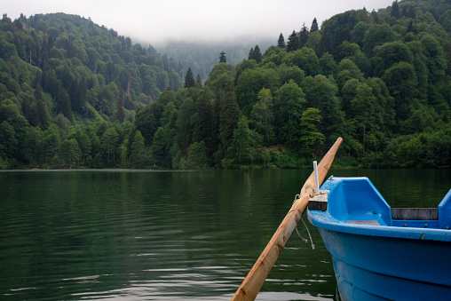 Blue small boat at the lake with shovel,long lake