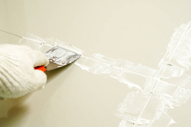 istock Tiler laying the ceramic tile on the floor. Grouting ceramic tiles. Professional worker makes renovation. Construction. Hands of the tiler. Home renovation and building new house. 1629679044