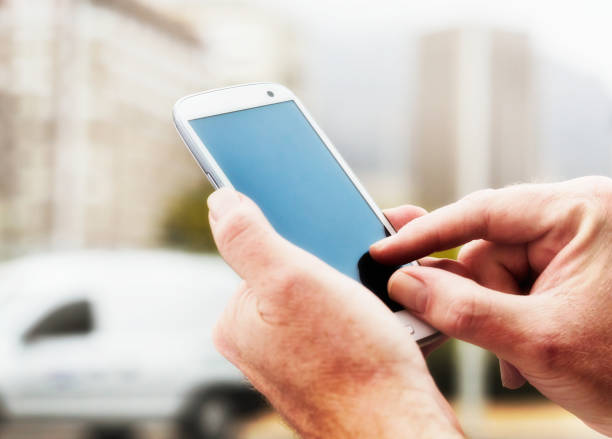 A man's hands touch the screen on a cellphone. The screen is blank, offering copy space for your message.