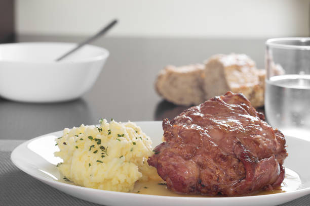 istock Pork knuckle with mashed potatoes with bread and glass with water 1629693824