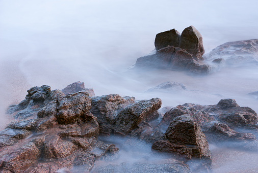Detail of rocks in the sea with strange shapes, the water has a silk effect due to the long exposure.