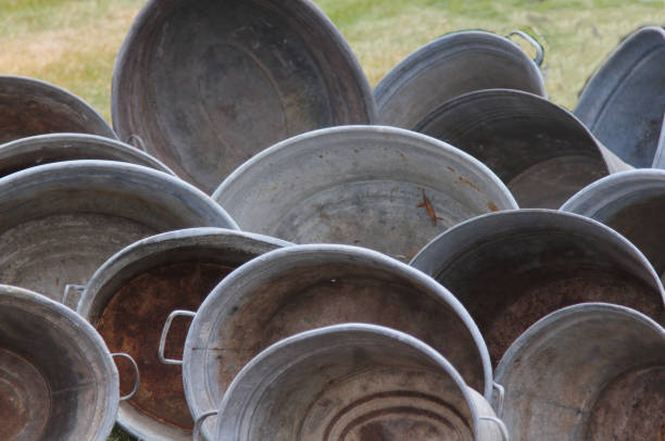 Many old-fashioned iron milk churns with lids in Friesland The Netherlands. Image with selective focus.