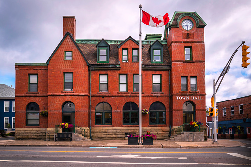 Historic red brick Antigonish Town Hall building and Canadian national Flag in Nova Scotia, Canada