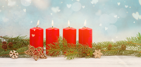 Red candles on a advent wreath with fir, christmas decoration with candlelight, winter holiday greeting card