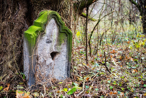 old stone cross in the autumn foliage
