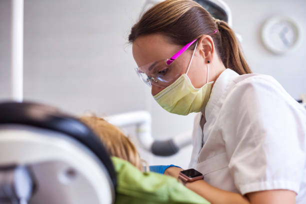 zubař lékař s ošetřující zuby holčička 5-6 let stará v zubní ordinaci, realistická fotografie. zubař dělá zuby dítě dívka na klinice. koncepce dětské stomatologie. kopírování reklamního textového prostoru - bolest zubů fotky - stock snímky, obrázky a fotky
