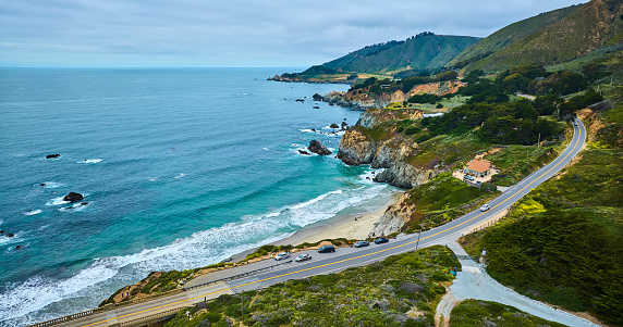 Image of Aerial with Highway One leading to entrance of One Rocky Creek Bridge with ocean coastline view