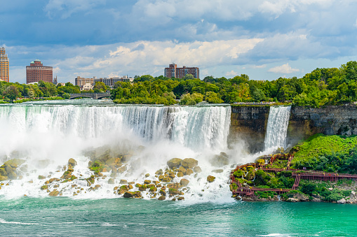 View on the Bridal Veil Falls and American Falls of the Niagara Falls, the part of Goat Island, the Cave of the Winds Lookout, stairs and platforms, wooden walkways, Niagara Falls, New York, USA.