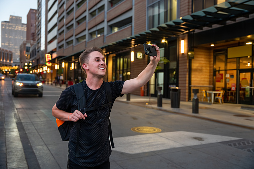Portrait Shot of a Tourist in his Late 20's Taking Selfies in Salt Lake City Utah on a Summer Evening