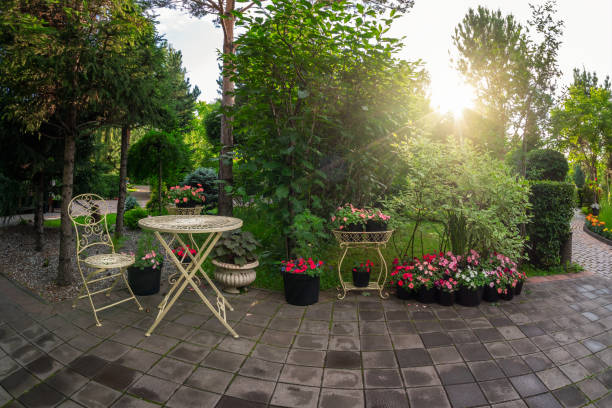 istock A cozy beautiful summer landscape park, an openwork wrought-iron table with a chair among flowerbeds with flowers in the evening in the sunlight. 1629797117