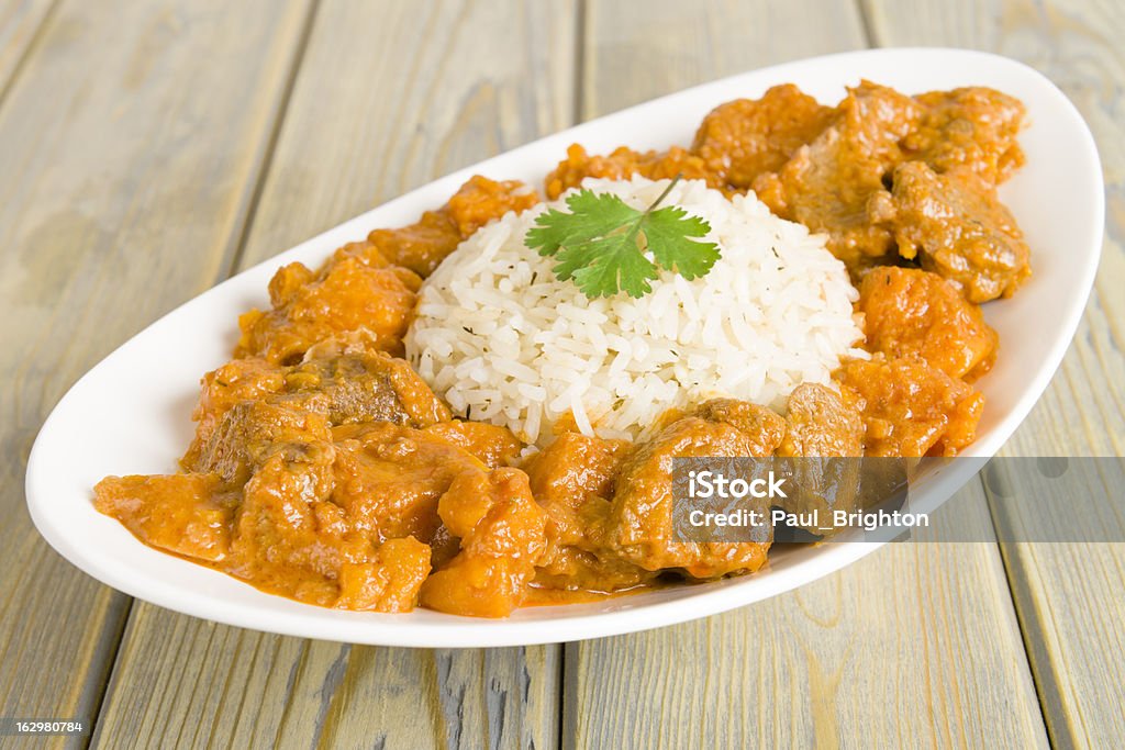 Caribbean Lamb and Sweet Potato Curry Lamb and sweet potato peanut stew served with white rice. Caribbean and West African traditional dish. Food Stock Photo