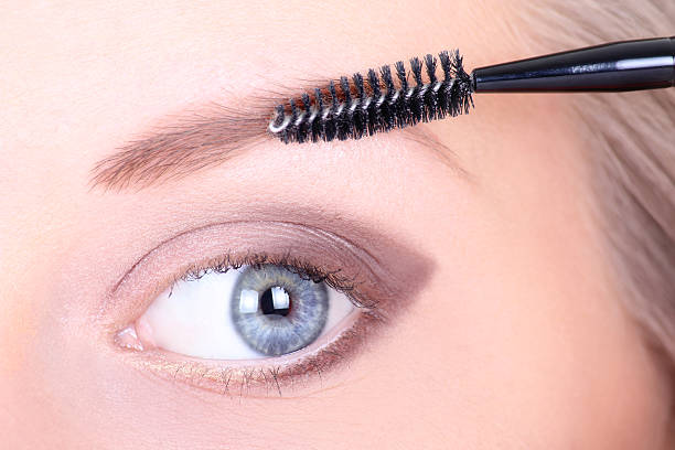 istock beautiful woman brushing eyebrows with makeup brush 162981019