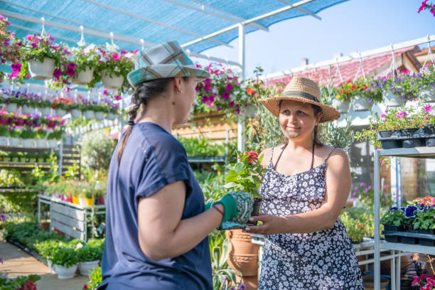 istock Two young women in a garden center. 1629816046