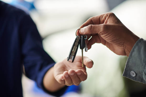 Giving Car Keys to Client Closeup image of mechanic giving car keys to client after repairing it car key stock pictures, royalty-free photos & images