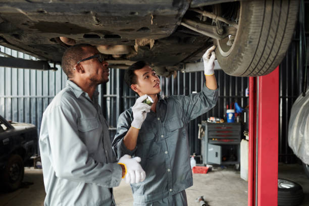 istock Mechanics Examining Suspended Car 1629822680
