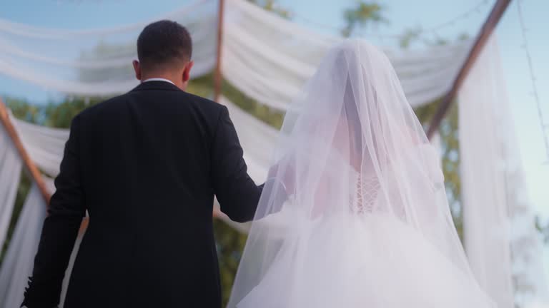 Bride and groom holding hands and walking