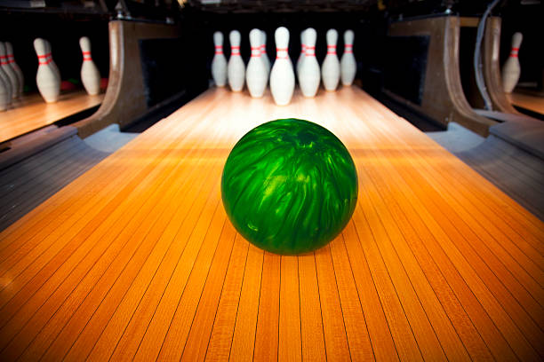 istock Green bowling ball headed toward ten standing pins 162984282