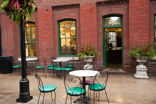 A cafe with bistro tables outside in Toronto's historical distillery district dressed up for Christmas on a rainy late autumn day.
