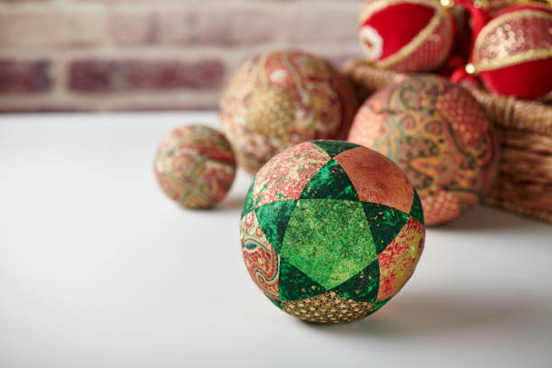 patchwork puzzle balls and christmas decorations in basket on brick wall background - christmas quilt craft patchwork imagens e fotografias de stock