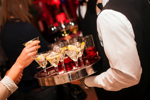 Waiter holding a tray full with Martini coctails