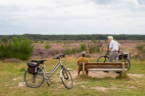 Laren, Netherlands, August 21, 2021; An elderly couple take a break from a bike ride in the Zuiderheide nature reserve near the village of Laren.