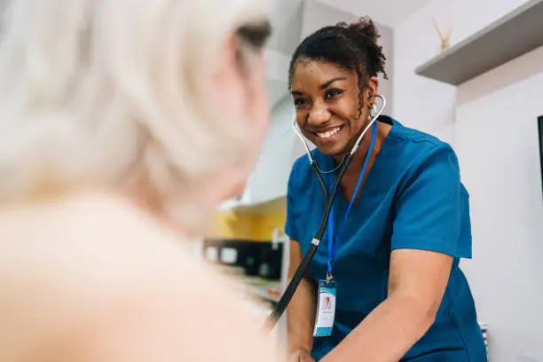 Nurse taking blood pressure of a patient at home