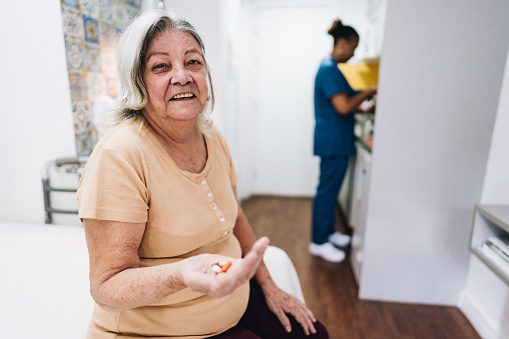 Portrait of a senior woman holding her medicine at home